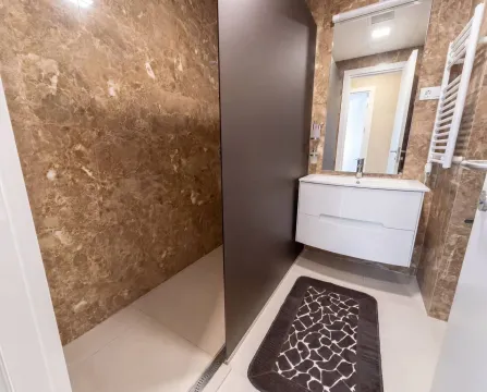 A modern bathroom with a walk-in shower and a vanity unit. - image 17