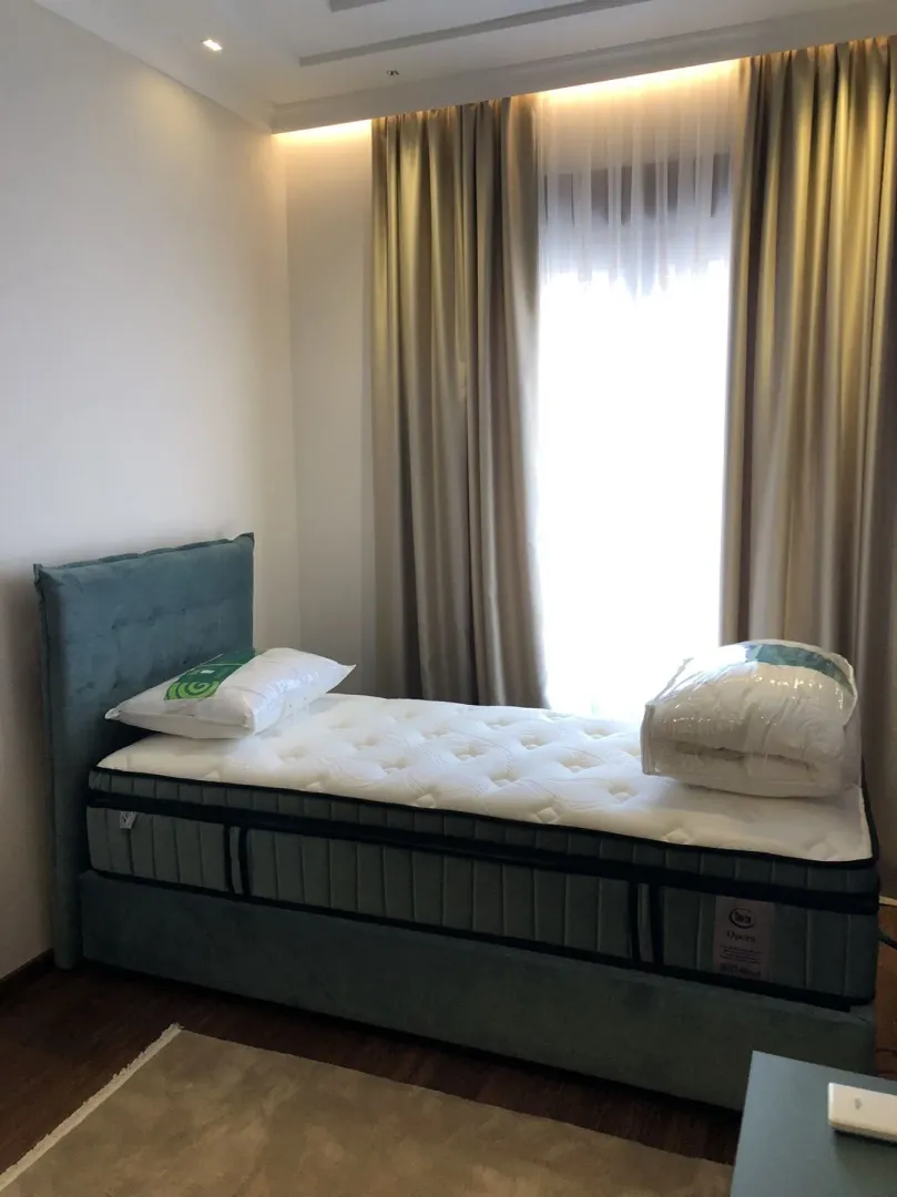 Bright bedroom featuring a single bed and modern curtains.