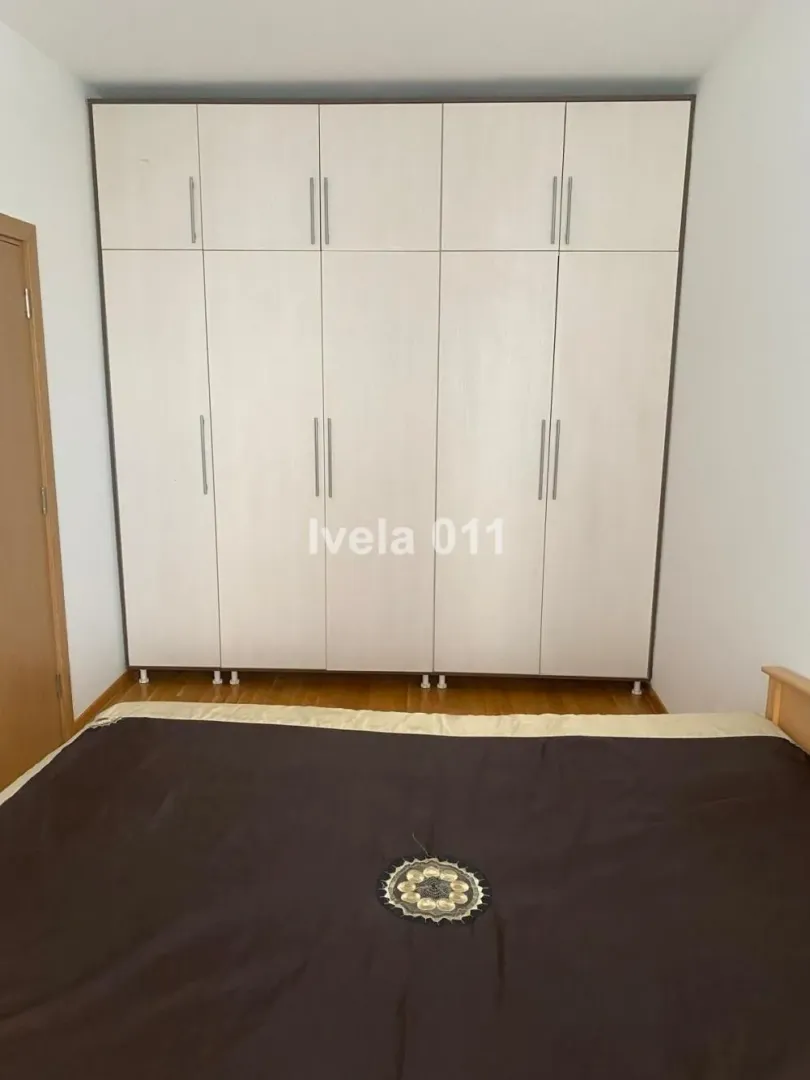 Spavaća soba sa velikim ugradnim garderoberom i bračnim krevetom.
