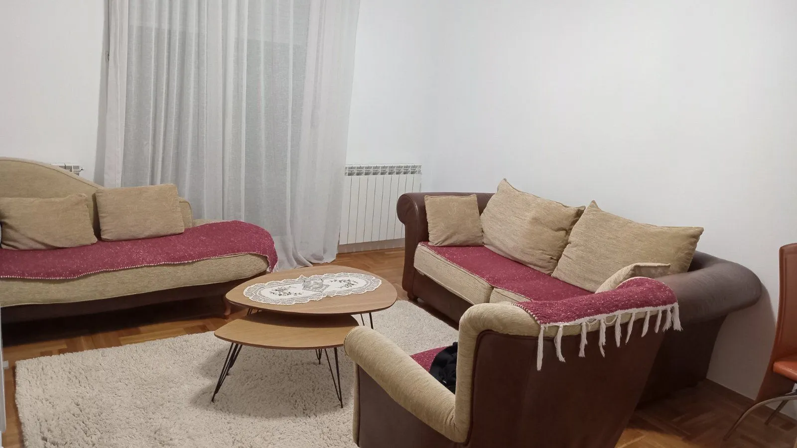 Bright living room with a seating set and a wooden coffee table.