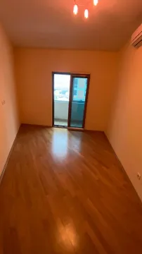 Prazna soba sa parketom i izlazom na balkon. - image 9