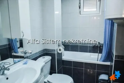 A compact bathroom featuring a bathtub, sink, and toilet, tiled with ceramic tiles. - image 19