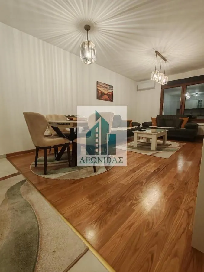 Living room with dining area and wooden flooring.