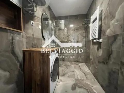 Modern bathroom with walk-in shower, washbasin, and marble-effect tiles. - image 15