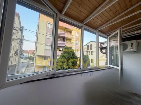 Zastakljeni balkon sa pogledom na okolne zgrade i ulicu. - image 11