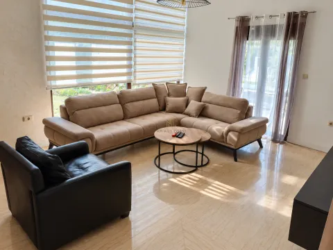 Living room with a large sectional sofa, a black armchair, and a round coffee table. - image 4