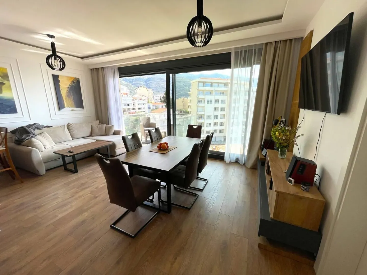 Living room with dining area and access to a balcony with city views.