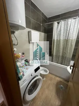 Bathroom with a bathtub, washing machine, and water heater. - image 6