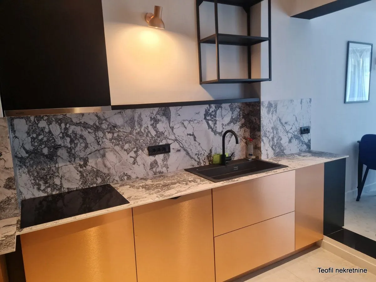 Modern kitchen with marble elements and copper fronts.