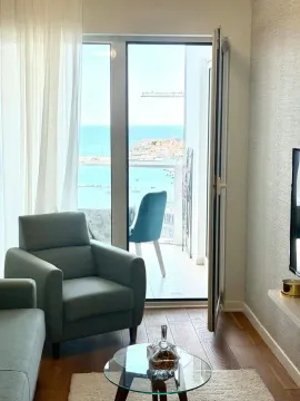 Living room with furniture and a sea view through the balcony door. - image 3