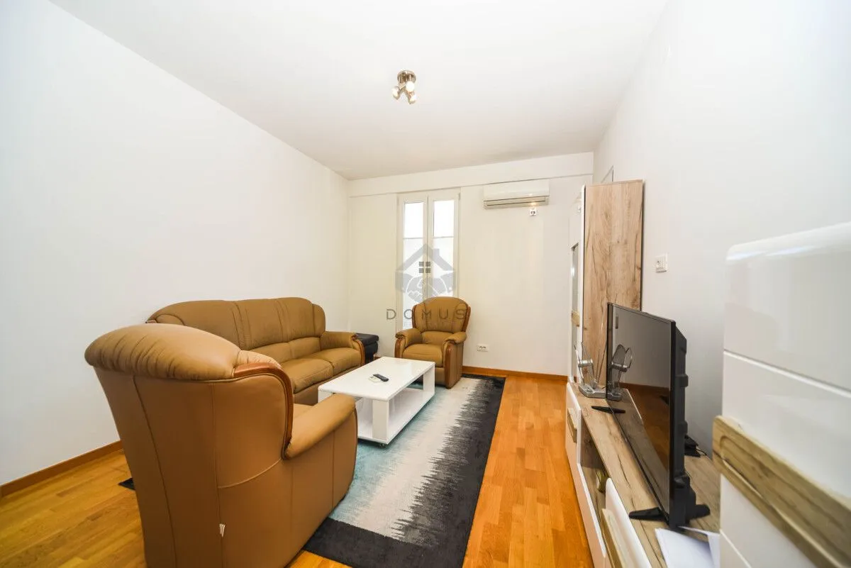 Living room furnished with a leather sofa suite, coffee table, and television.