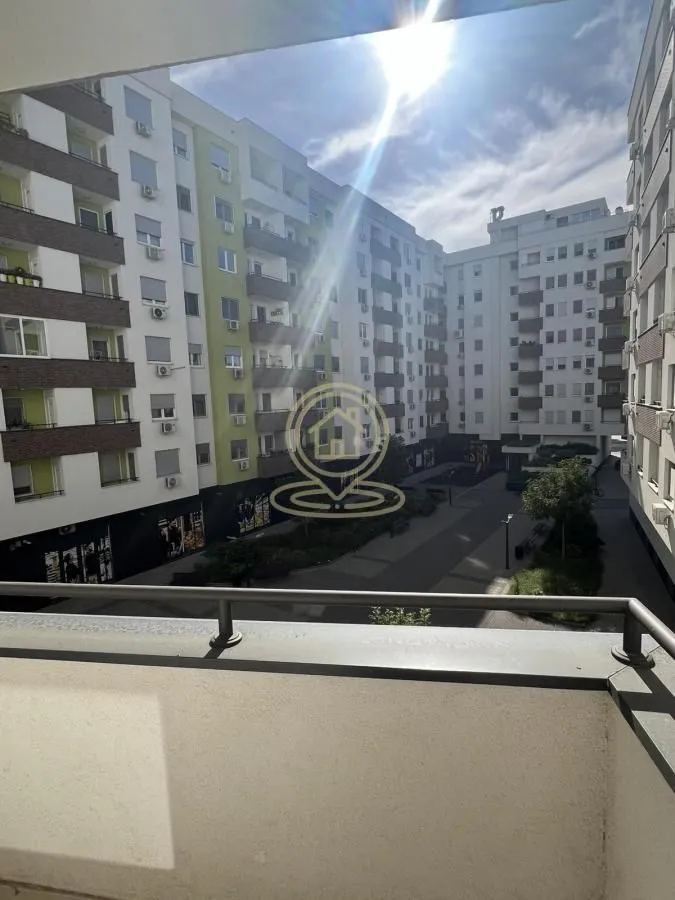 Pogled sa balkona na dvorište i okolne stambene zgrade.