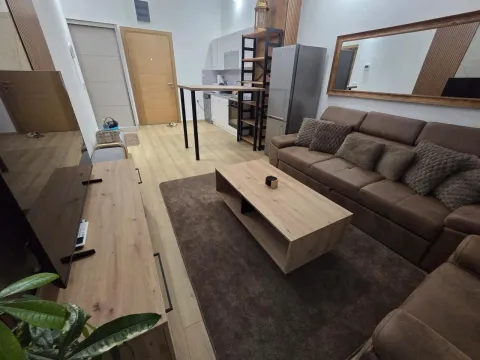 Living room with sofa, TV unit and kitchen in the background. - image 3