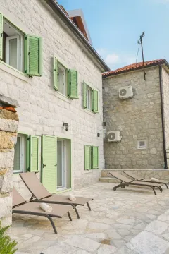 Dvorište kamene kuće sa ležaljkama za sunčanje. - image 6