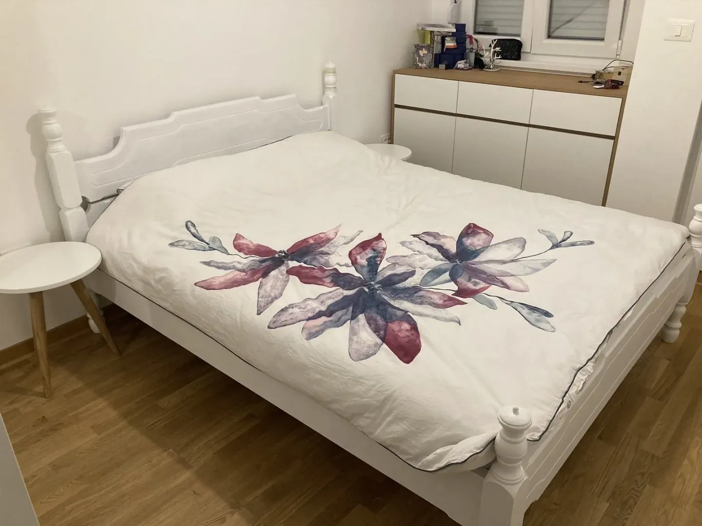 Bright bedroom with a white double bed and a dresser.