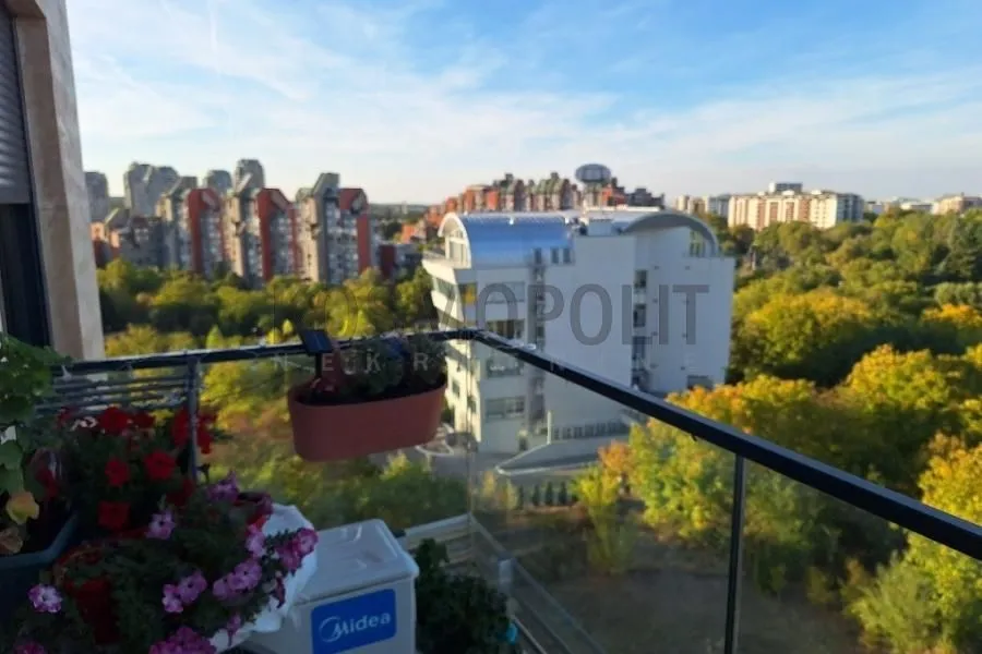 Pogled sa terase na okolne zgrade i zelenilo.