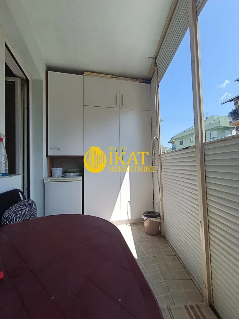 Zastakljeni balkon sa ugradnim ormarom i stolom.