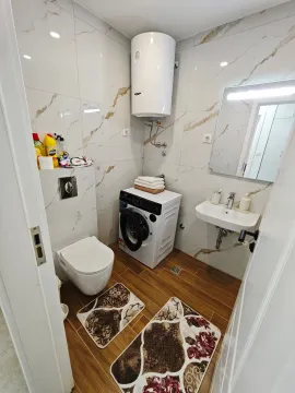 Modernly equipped bathroom with a washing machine and water heater. - image 6