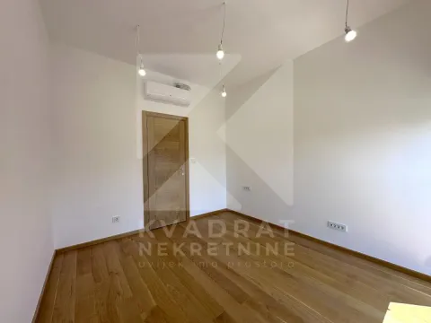 Empty room with wooden flooring, an air conditioning unit, and a door. - image 9