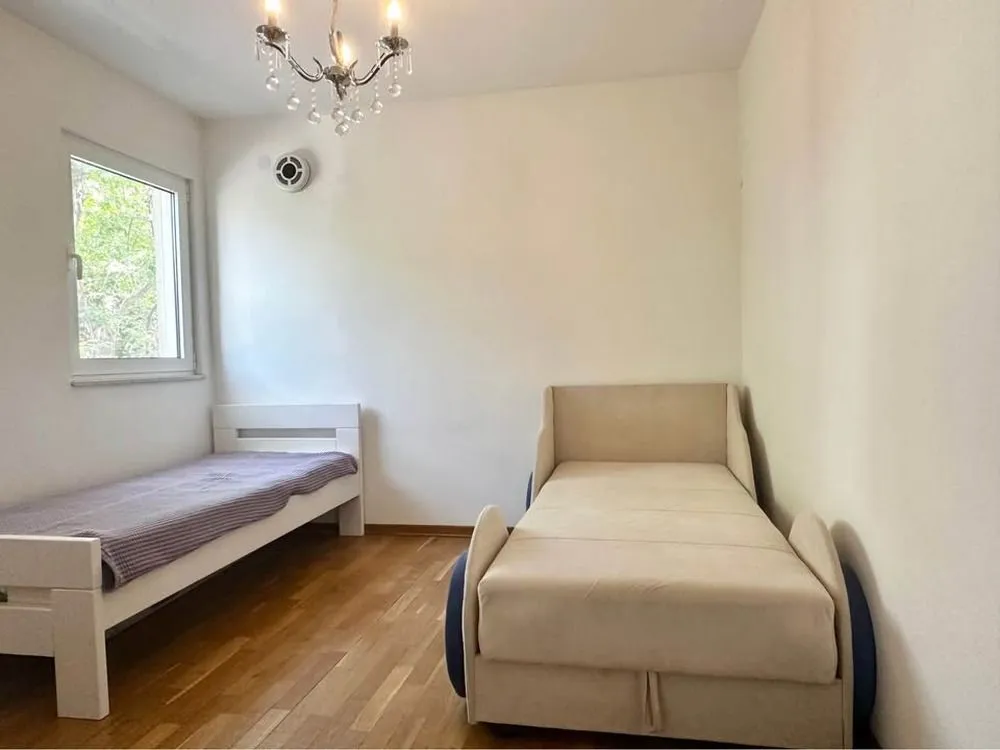 Bedroom with two beds and wooden flooring.