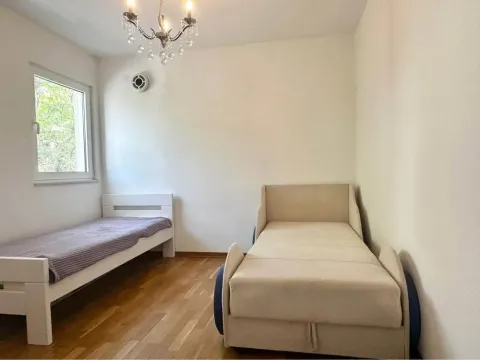 Bedroom with two beds and wooden flooring. - image 7