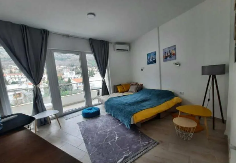Bright bedroom with a bed, floor lamp, and access to the terrace.