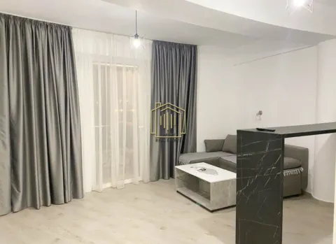 Living room with sofa, coffee table, and balcony doors with grey curtains. - image 2