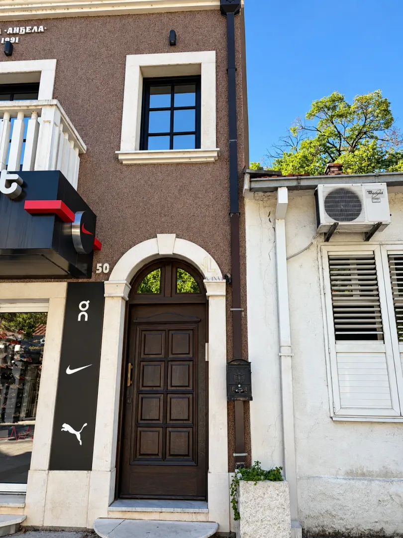 View of the entrance and facade of a mixed-use building from the street side.