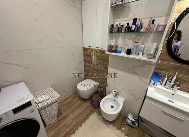 Moderne kupatilo sa sanitarijama, umivaonikom i veš mašinom.