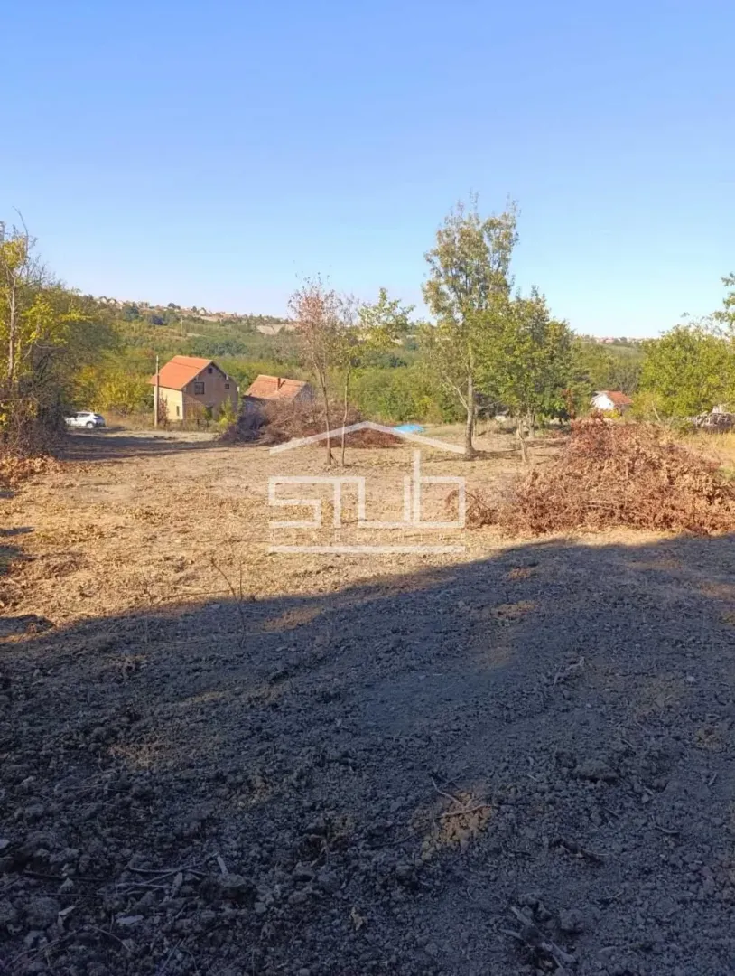 Pogled na plac sa zelenilom i drvećem u okolini.