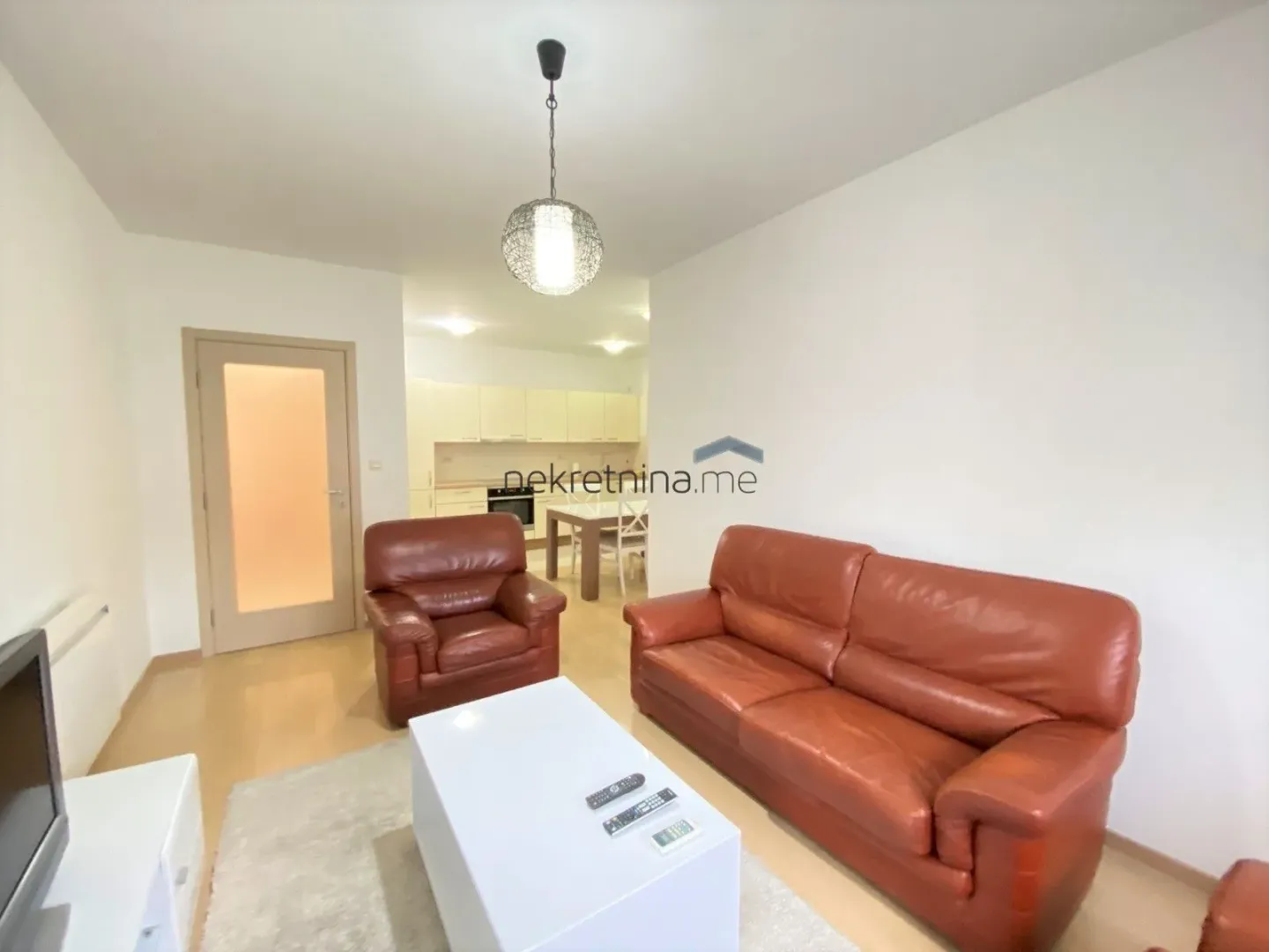 Living room with a leather sofa set and a view of the kitchen.
