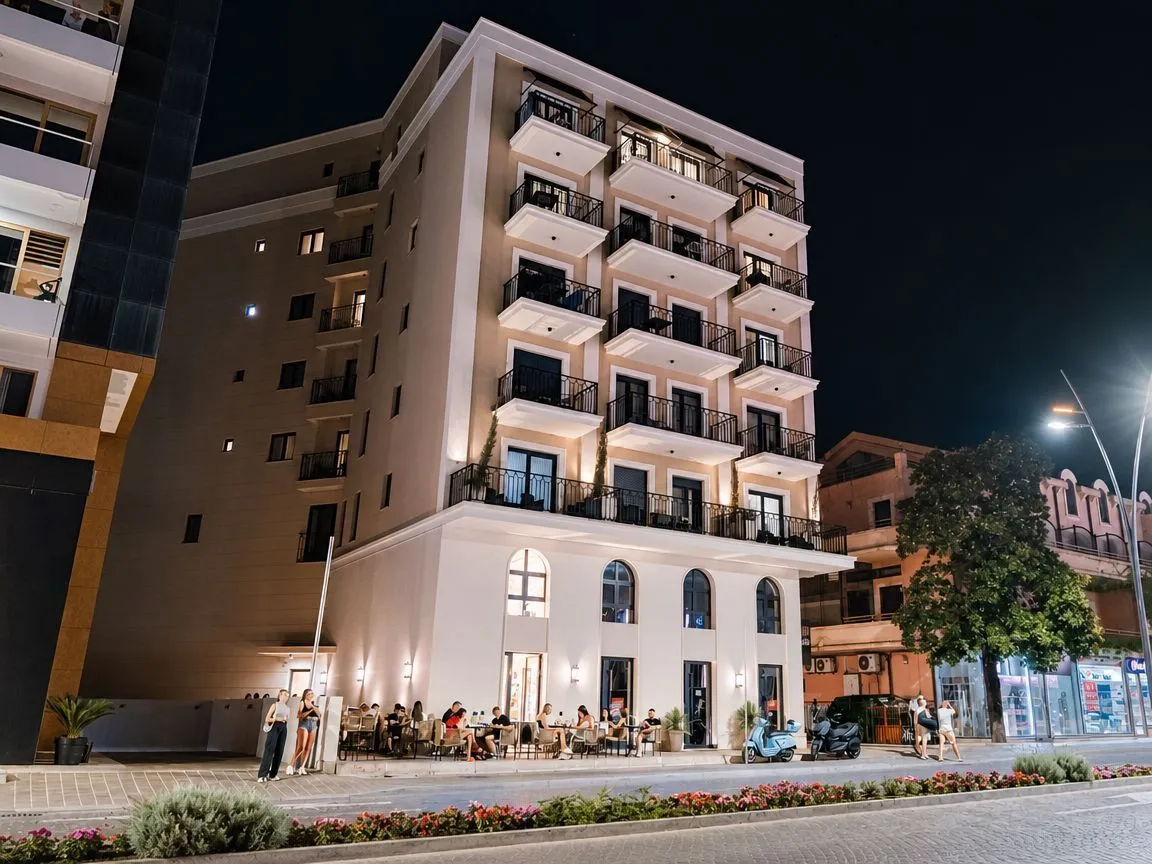 Night view of the exterior of the residential building with balconies and a ground floor venue.
