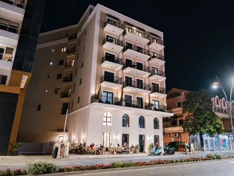 Night view of the exterior of the residential building with balconies and a ground floor venue. - image 4