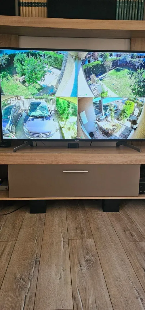 Television displaying video surveillance cameras on a TV unit in the living room.