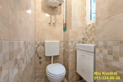 Manje kupatilo obloženo keramičkim pločicama sa WC šoljom, umivaonikom i bojlerom. - image 3