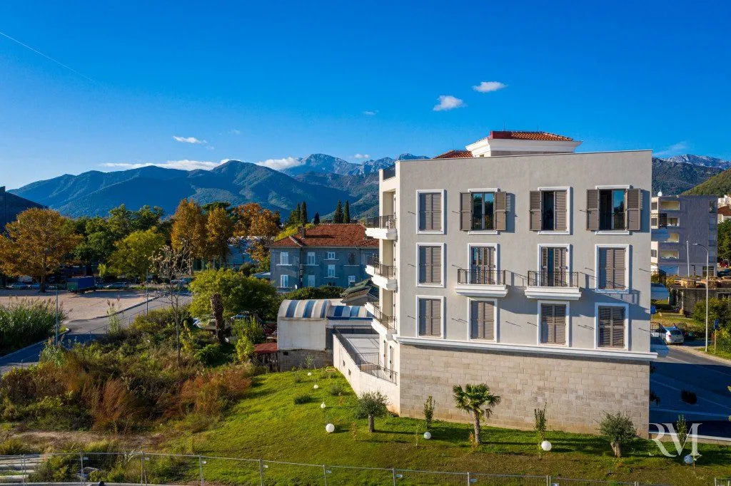 View of the building exterior with surrounding landscape and mountains in the background.