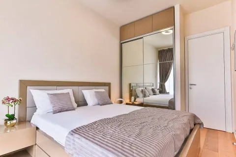 Furnished bedroom with a double bed, large mirrored wardrobe, and a white door. - image 7