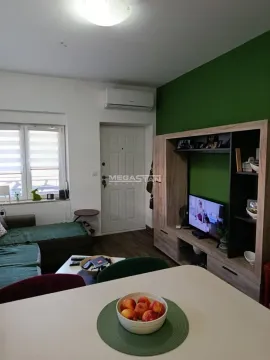 Living room with sofa, TV, and dining table. - image 2