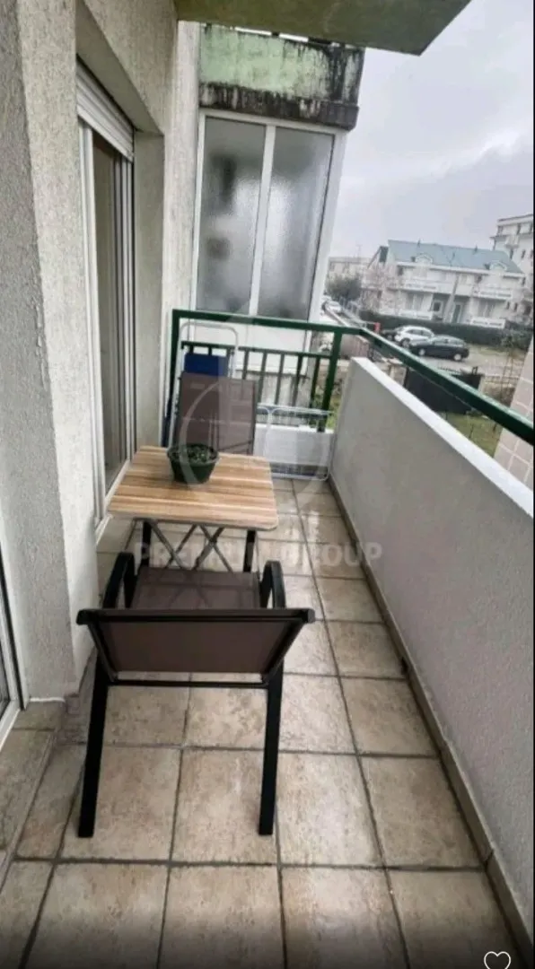 Uski balkon sa stolom i stolice.