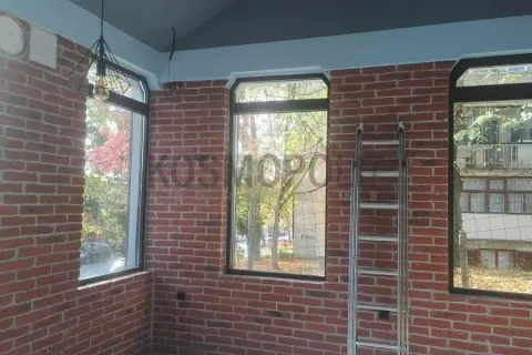 Unfinished room with brick walls and large windows. - image 11