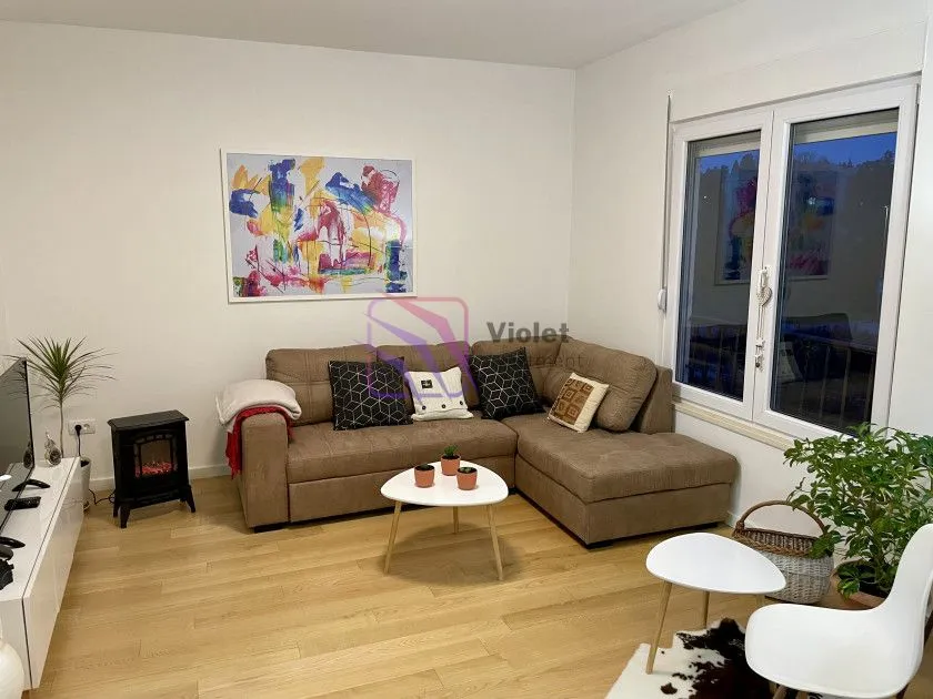 Living room with a sectional sofa, coffee table and TV unit.