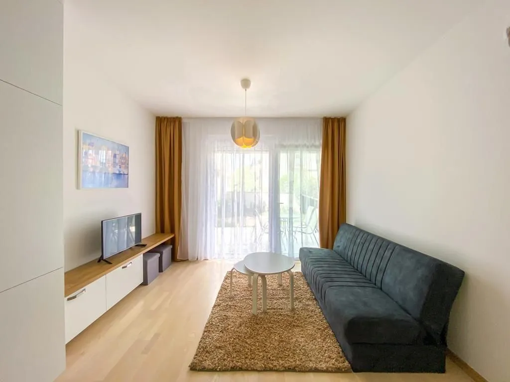 Living room with sofa, TV unit, and access to the terrace.
