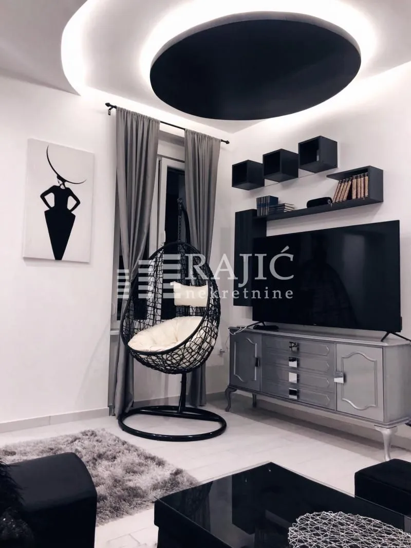 Modern and bright living room with seating and hanging shelves.