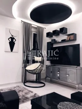 Modern and bright living room with seating and hanging shelves. - image 3