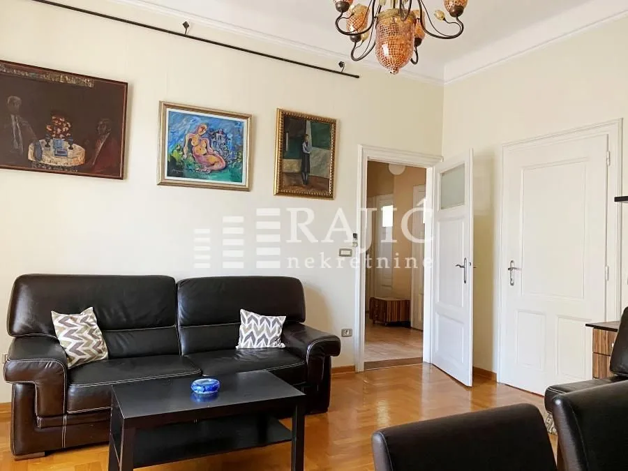 Living room with leather sofa and paintings on the wall.