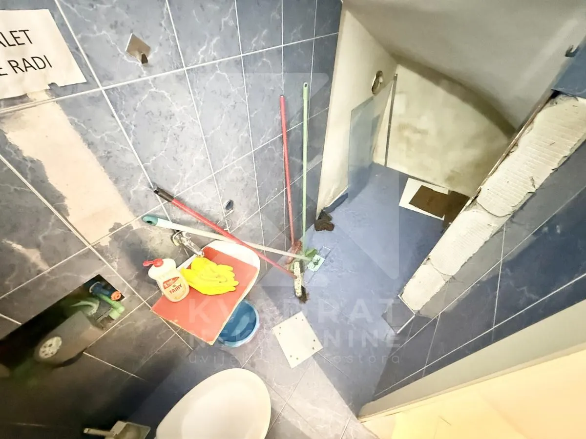 Bathroom under renovation with sanitary fixtures and cleaning supplies.