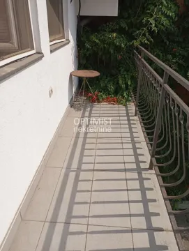 Small tiled balcony with a metal railing and a small table. - image 12