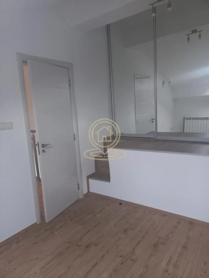 Small room with white door and built-in mirrored wardrobe.