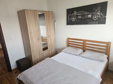 Furnished bedroom with a double bed and a wooden wardrobe. - image 9