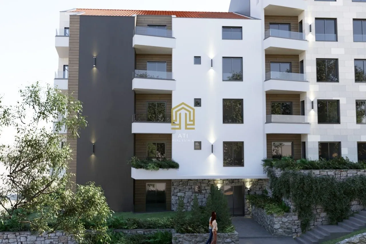 Spoljašnji izgled moderne stambene zgrade sa terasama i uređenim dvorištem.